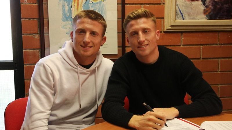 Pol Domingo amb el seu germà bessó en la signatura de renovació. | Foto: Gimnàstic de Tarragona